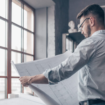 Mature engineer with a drawing indoors